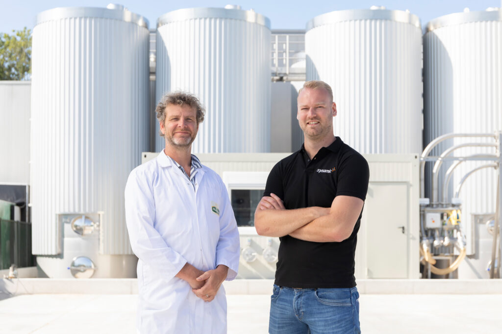 Atso de Jong of Oliehoorn and Bas Veenstra of Synamic in front of stainless steel tanks at Oliehoorn’s sustainable factory by Gpi