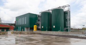 Green stainless steel storage tanks with platforms next to industrial building at Cargill Gouda